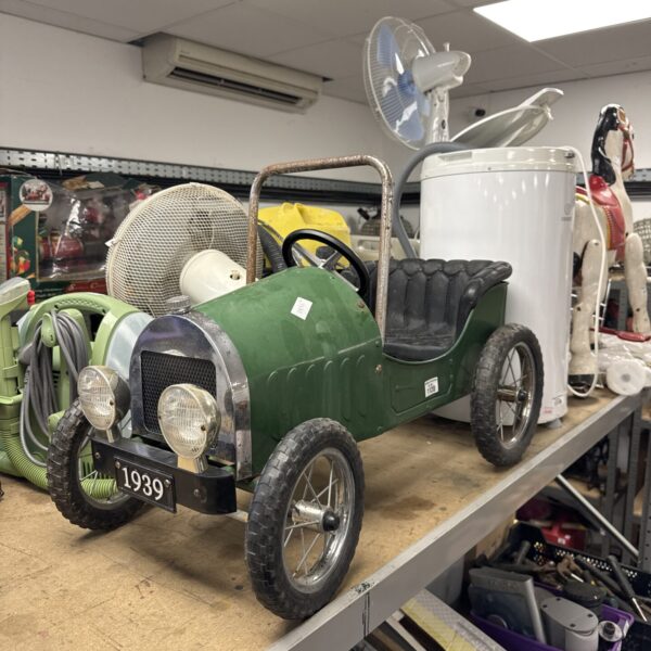 Green vintage pedal car, classic retro toy for collectors.