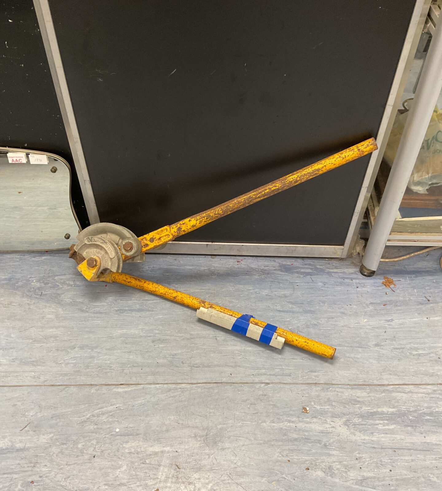 Vintage yellow pipe bender for metalworking and plumbing projects.
