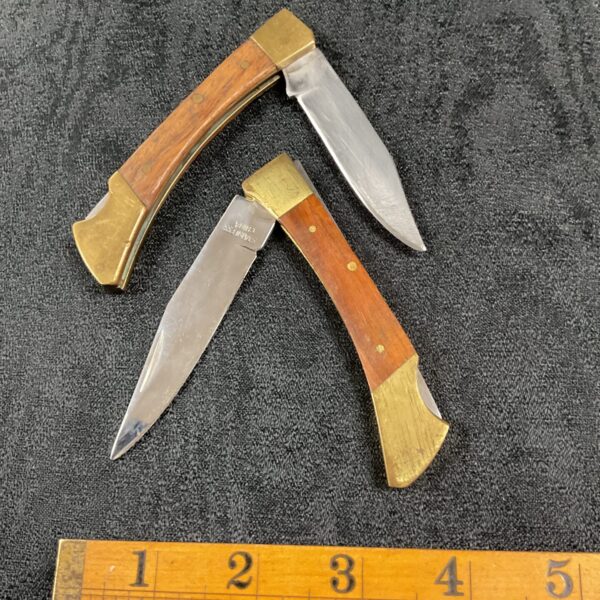 Vintage lot of two blade folding pocket knives with wooden handles.