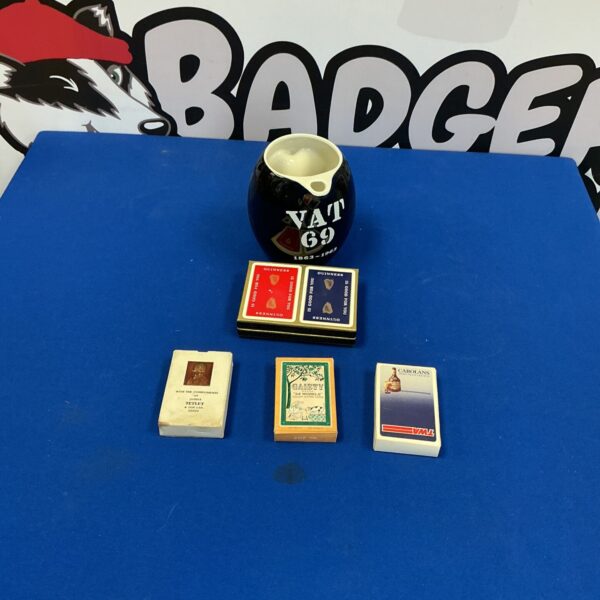 Vintage pub ephemera including VAT69 water jug and playing cards.