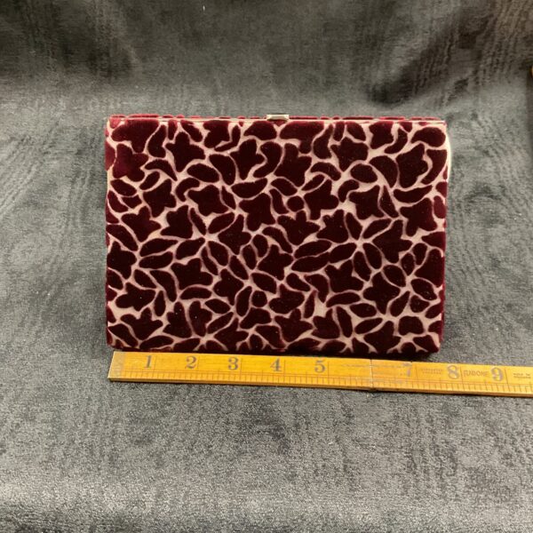 Front view of a vintage red velvet clutch purse with embossed pattern.