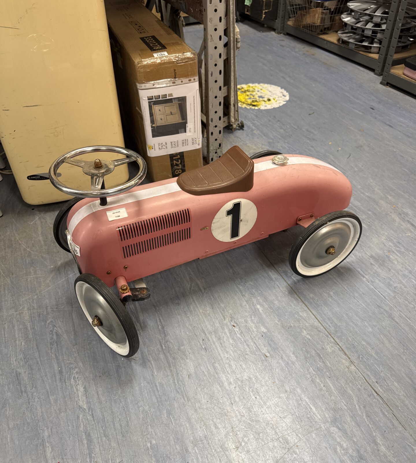 Pink vintage ride-on car for children, classic retro toy.