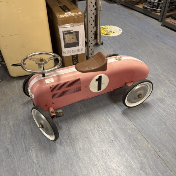 Pink vintage ride-on car for children, classic retro toy.