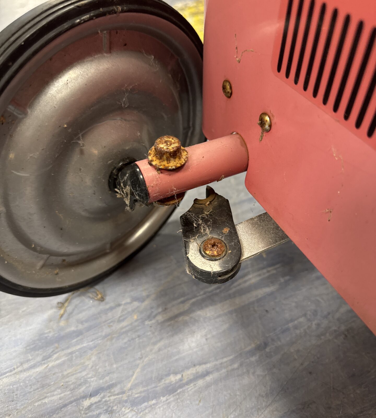 Broken steering arm bracket on vintage ride-on car.