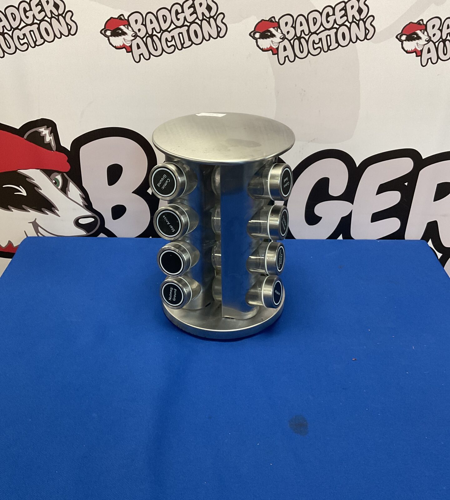 Vintage metal rotating spice rack with glass jars.
