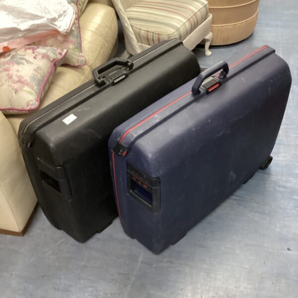 Two large vintage Samsonite suitcases with black and navy shells.