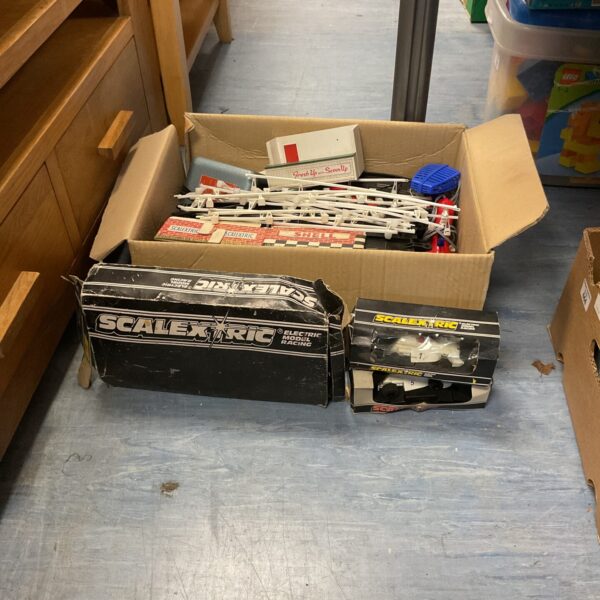 Vintage Scalextric set with cars and track pieces inside a box.