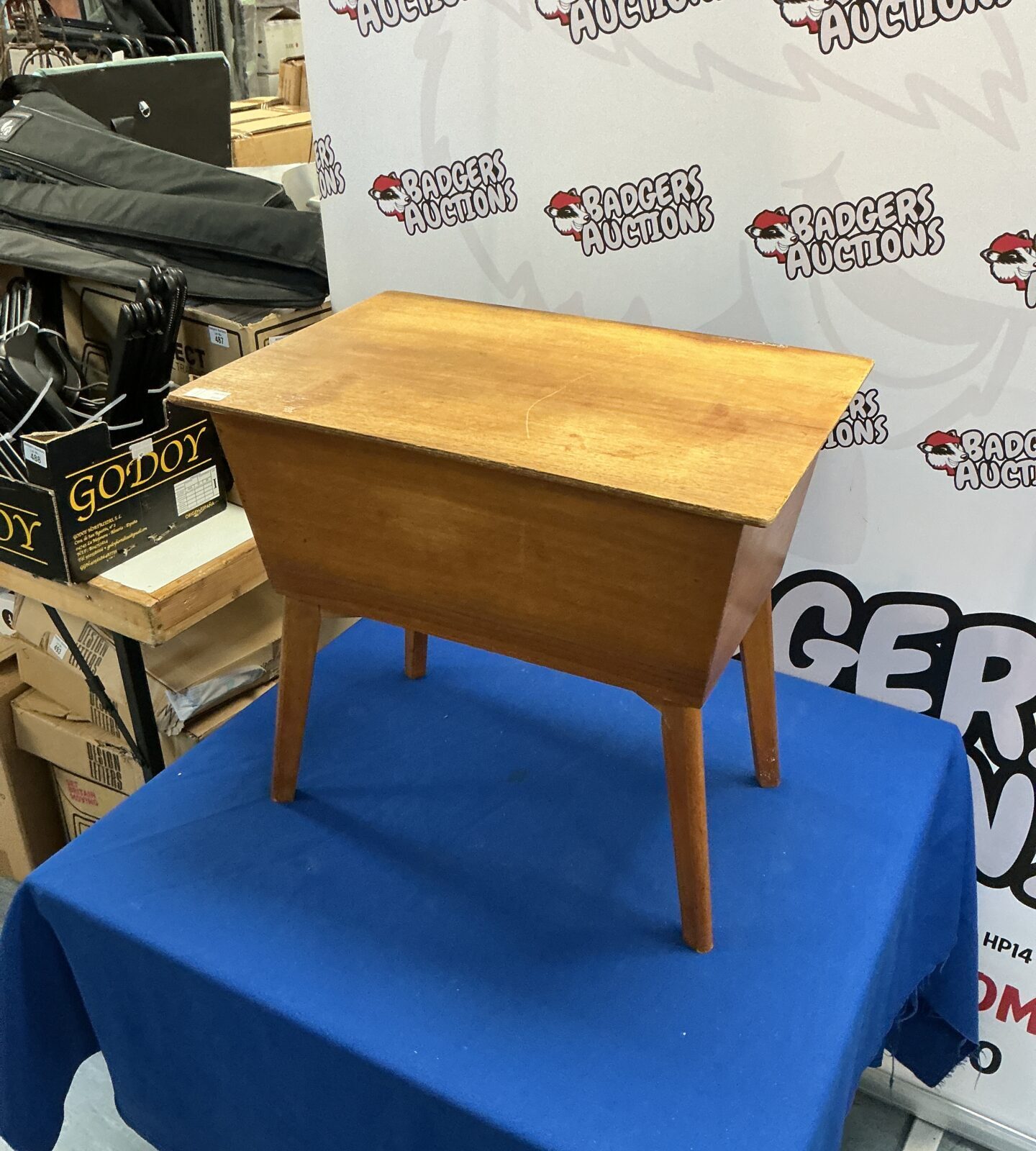 Vintage wooden sewing box displayed on a blue drape.