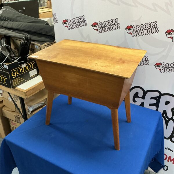 Vintage wooden sewing box displayed on a blue drape.