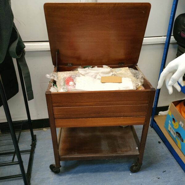 Vintage wooden sewing box trolley with open lid and contents.