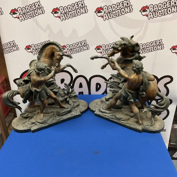 Pair of vintage spelter horse and farrier sculptures on display.