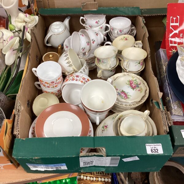 Mixed lot of vintage tea cups and saucers on display.