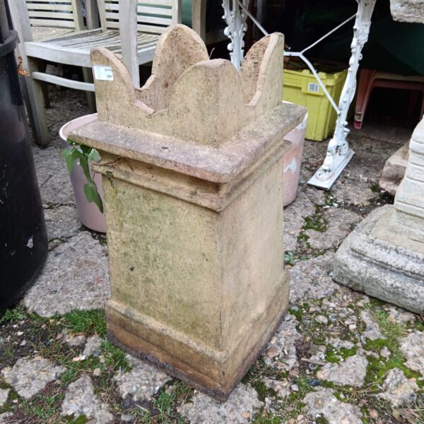 Weathered vintage terracotta chimney pot in a garden setting.