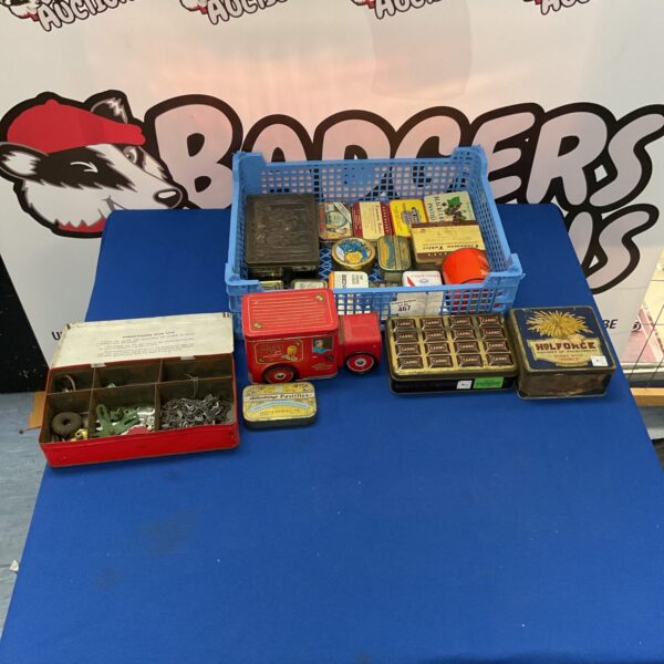 Vintage tin collection with Meccano parts inside, retro storage.