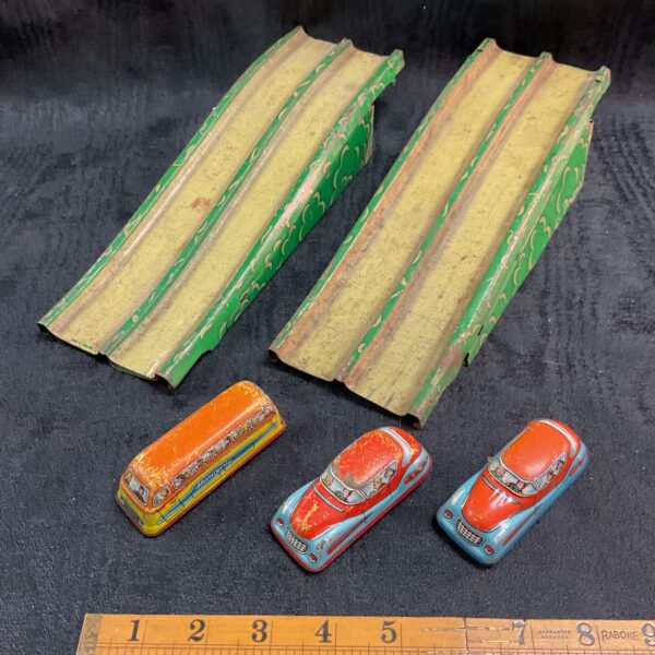 Vintage tinplate bridge ramps with clockwork cars and coach.
