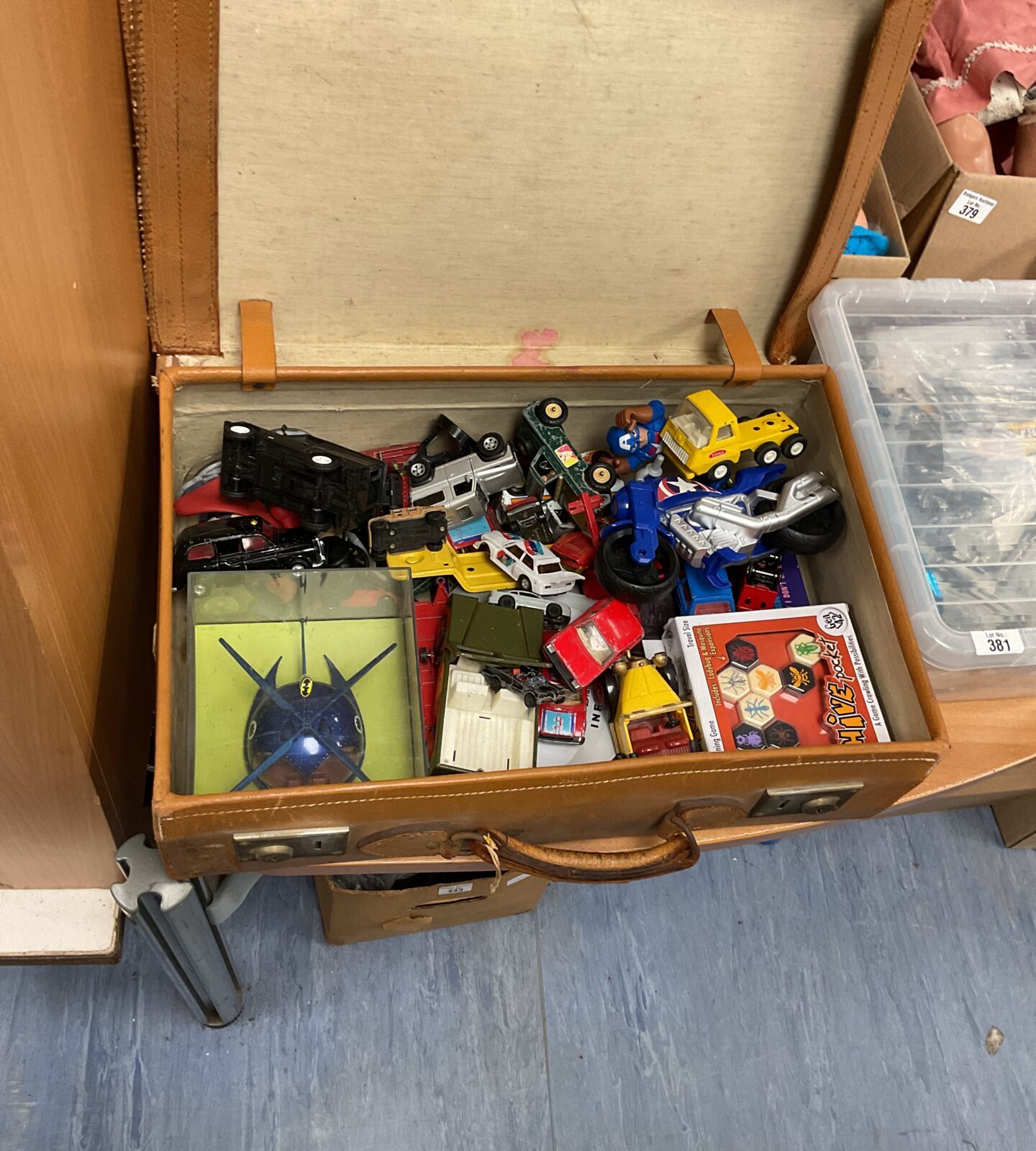 Vintage suitcase filled with a collection of diecast toys and Tonka vehicles.
