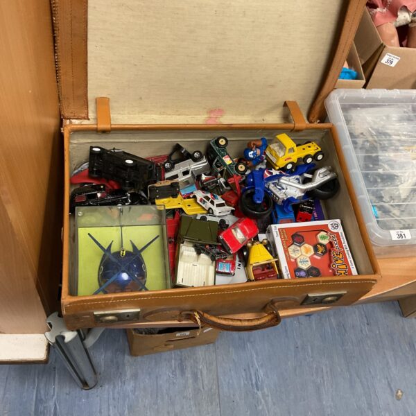 Vintage suitcase filled with a collection of diecast toys and Tonka vehicles.