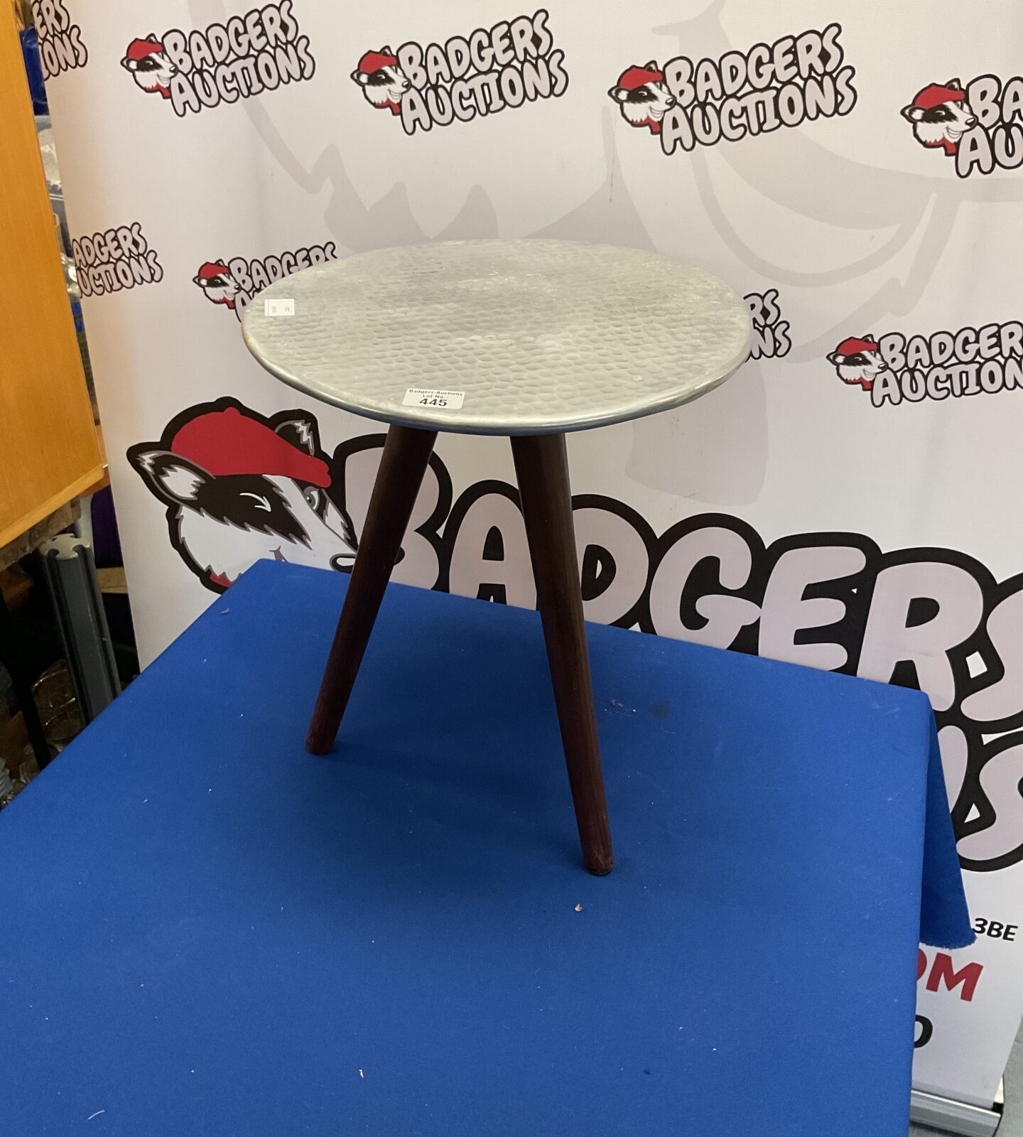 Vintage tripod table with hammered aluminium top for display.