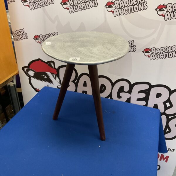 Vintage tripod table with hammered aluminium top for display.