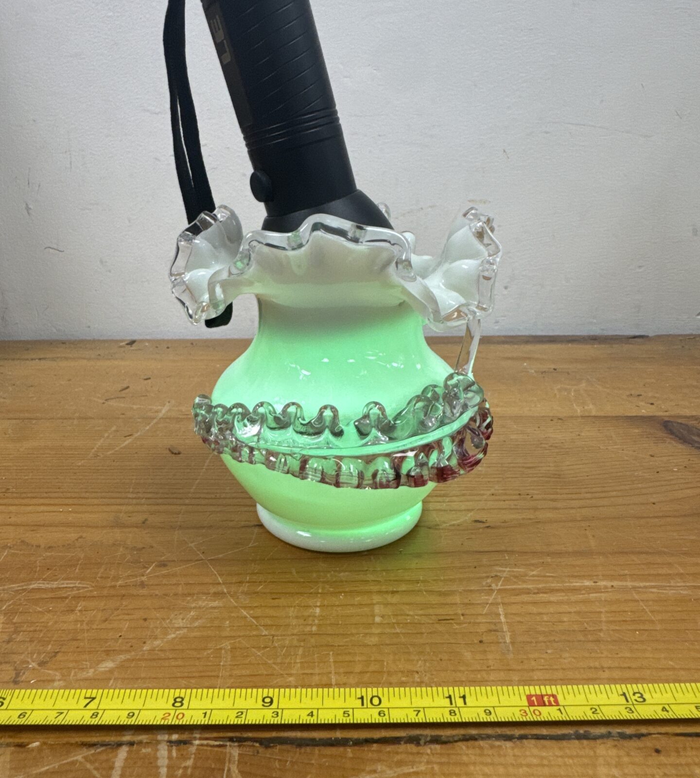 Side view of vintage green uranium glass vase.