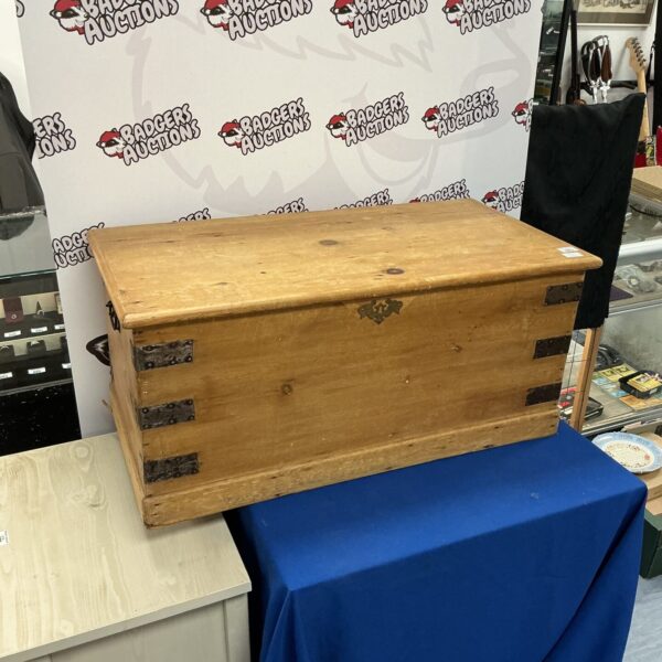Front view of a vintage wooden storage chest with rustic details.