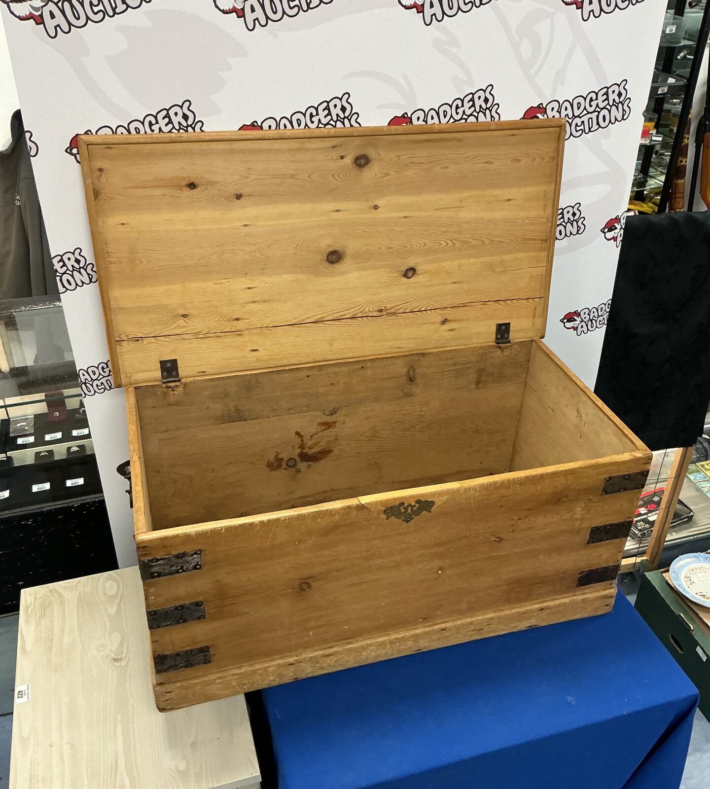 Side view of a vintage wooden storage chest with visible wear.