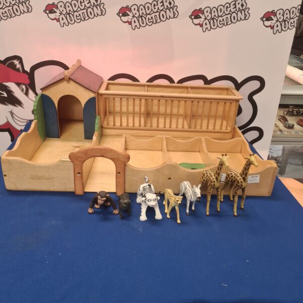 Vintage wooden farm playset with barn and animal figurines.