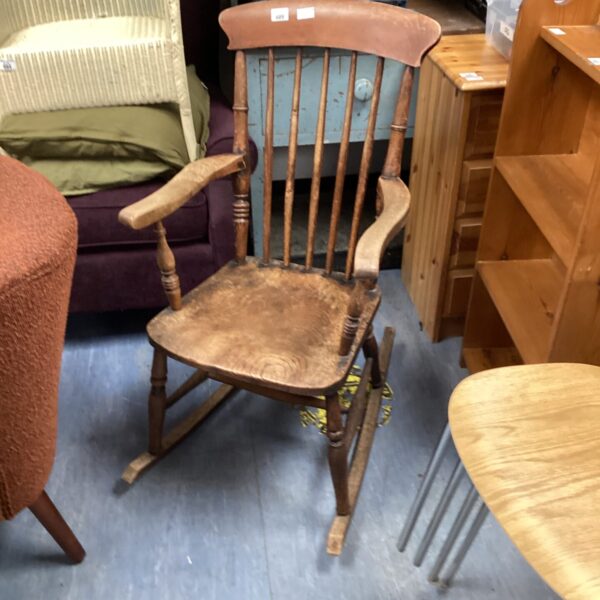 Vintage wooden rocking chair with curved back and armrests.