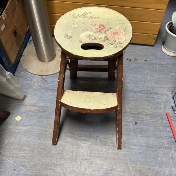 Vintage wooden step stool with floral design for kitchen use.