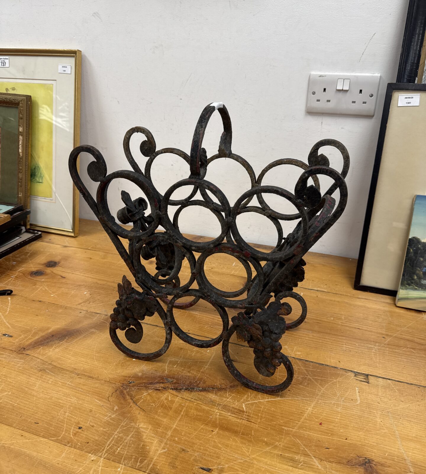 Ornate vintage wrought iron bottle rack for wine storage.