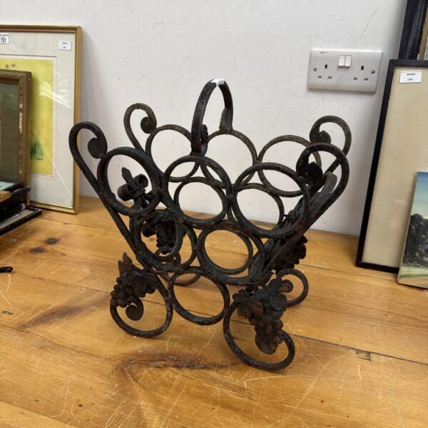 Ornate vintage wrought iron bottle rack for wine storage.