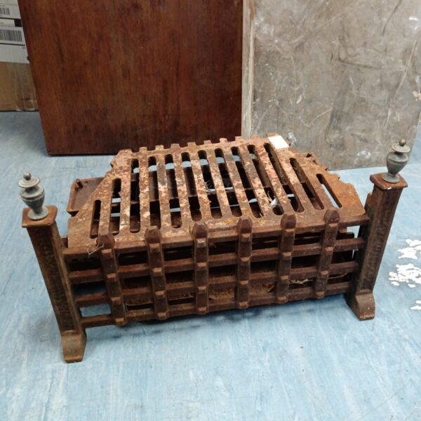Vintage wrought iron fireplace grate with decorative corner posts.