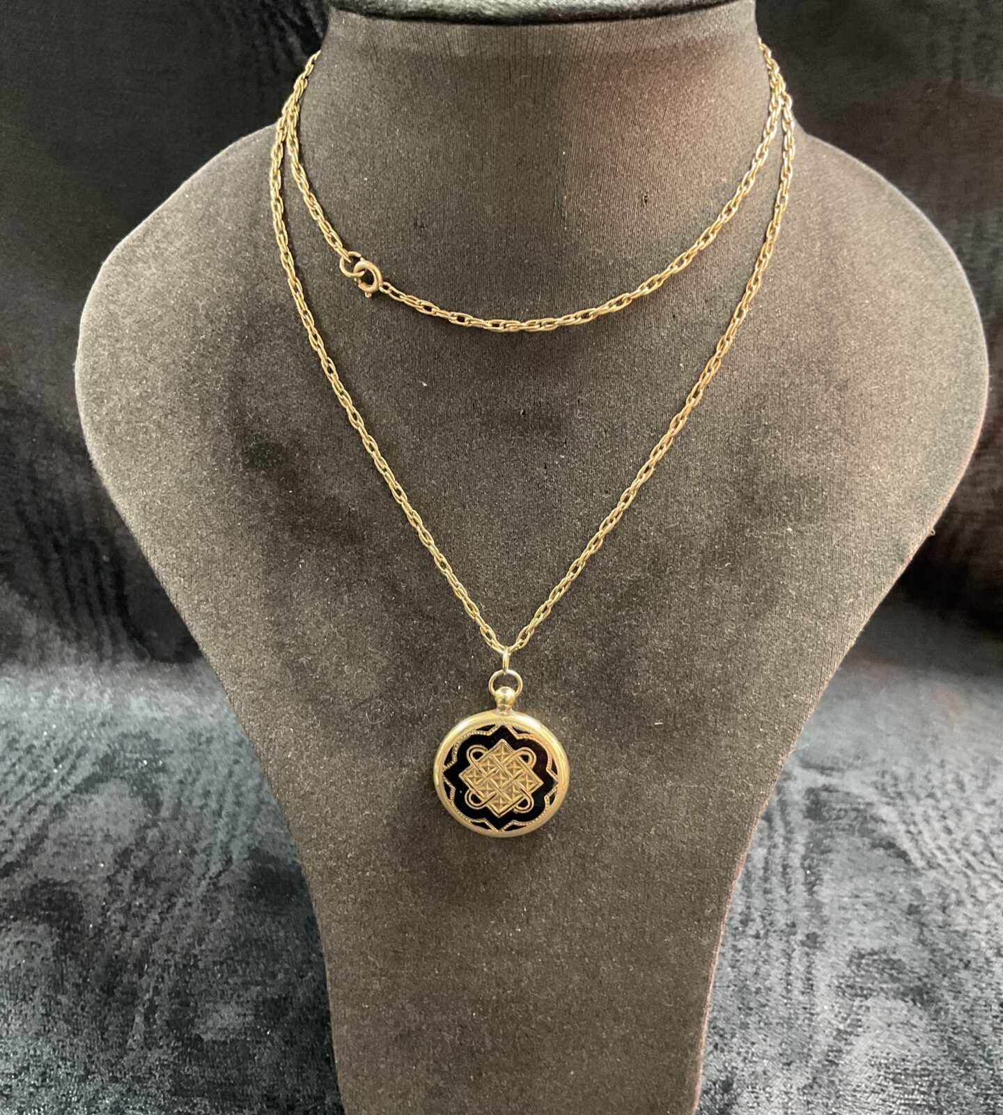 Ornate vintage yellow metal locket on a 24 inch necklace.