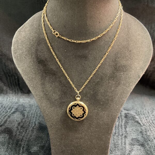 Ornate vintage yellow metal locket on a 24 inch necklace.