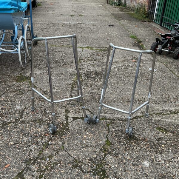 Pair of used walking frames for mobility assistance.