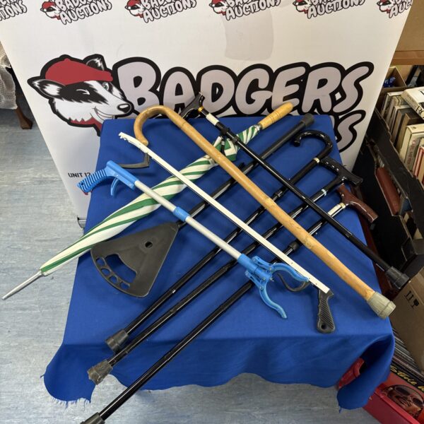 Selection of walking sticks, reach grabbers, and an umbrella for mobility assistance.