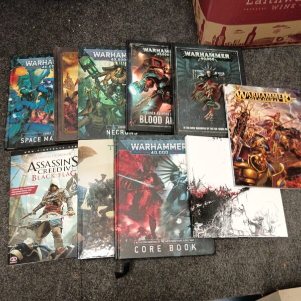 Warhammer 40,000 rulebooks and video game guides collection for tabletop gaming.