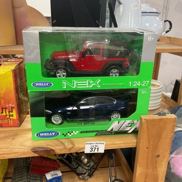 Two boxed Welly NEX 1:24 scale diecast model cars.