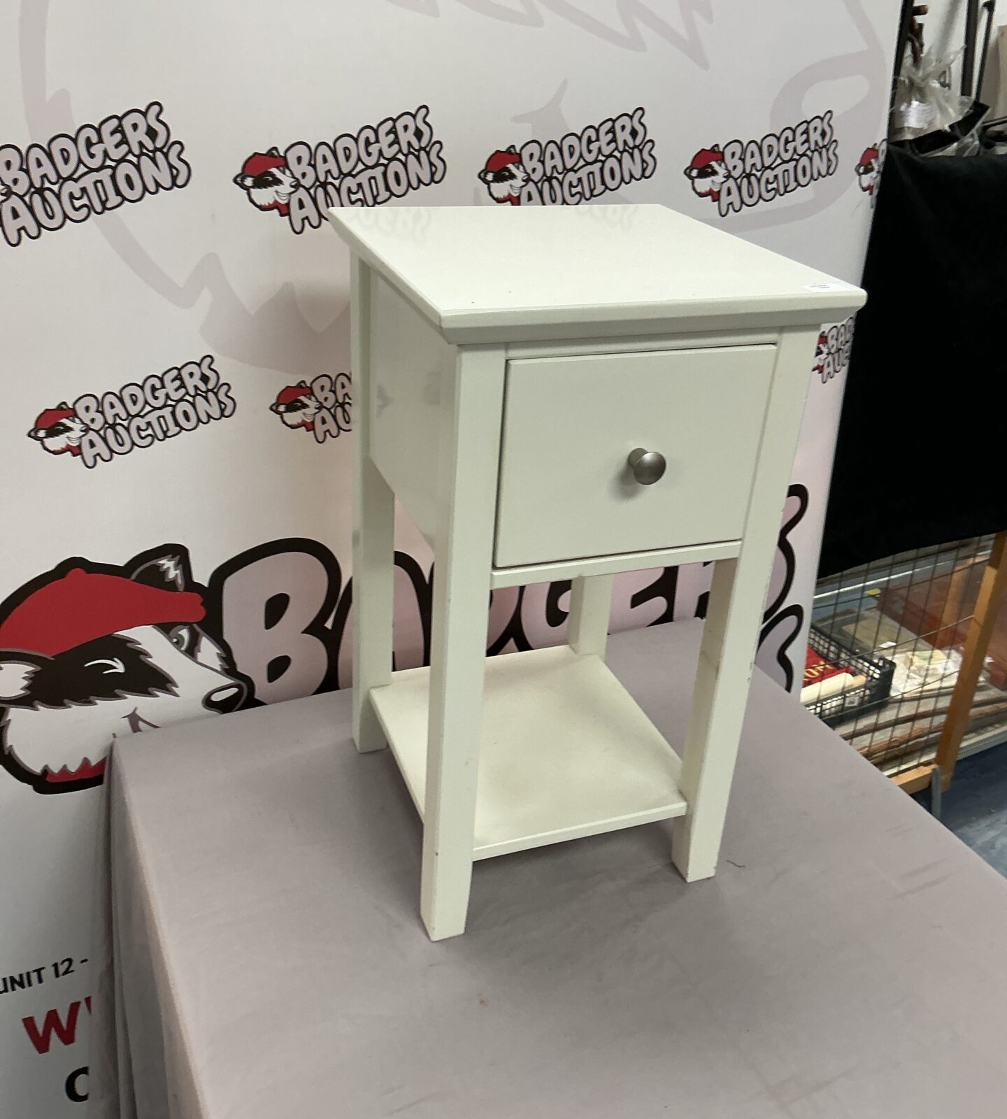 White bedside cabinet with a single drawer, ideal for bedroom storage.