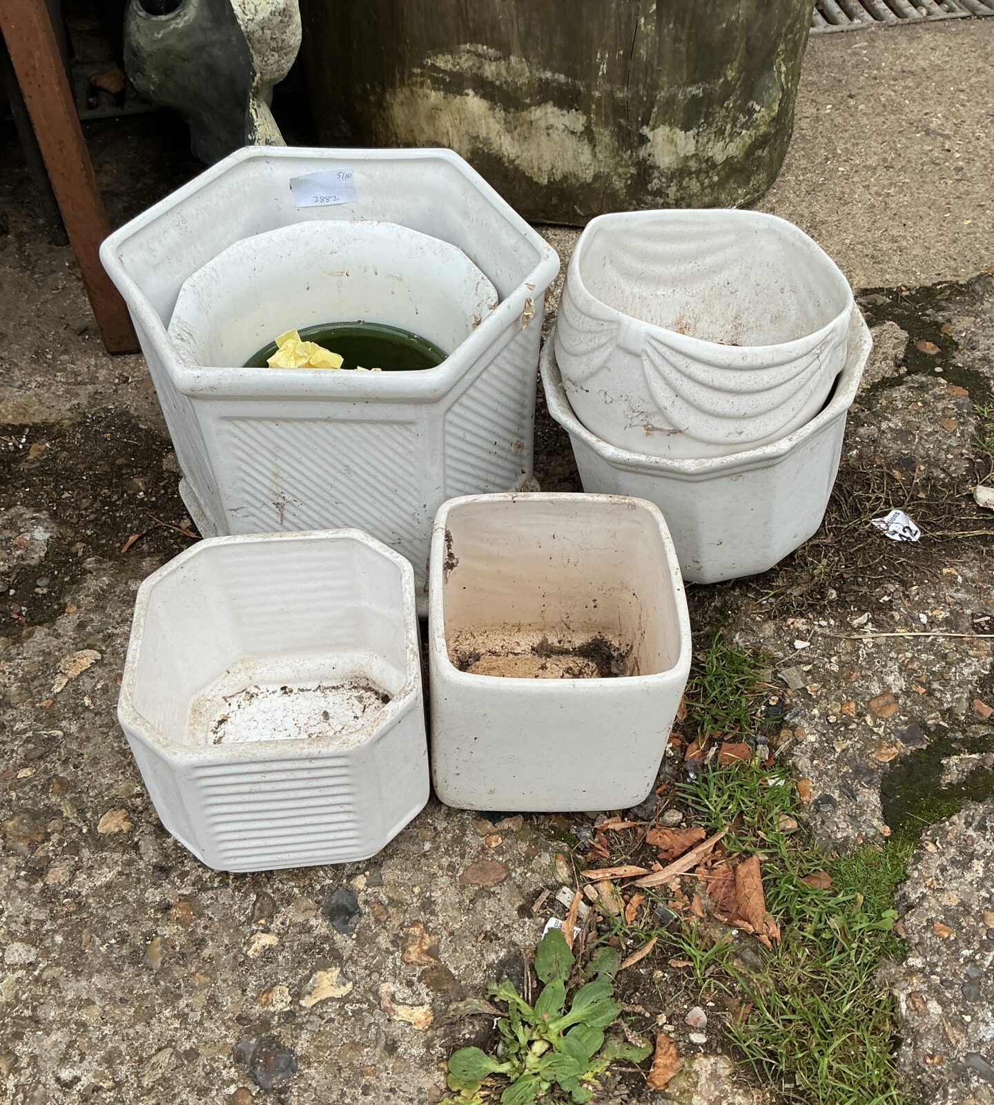 Set of three white hexagonal terracotta garden pots.