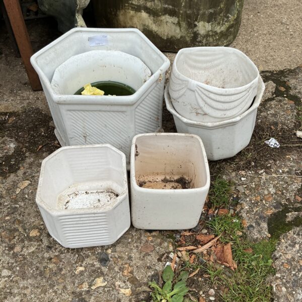 Set of three white hexagonal terracotta garden pots.