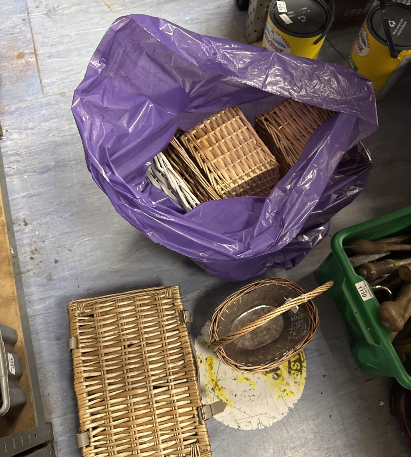 Purple bag filled with a variety of wicker baskets and trays.
