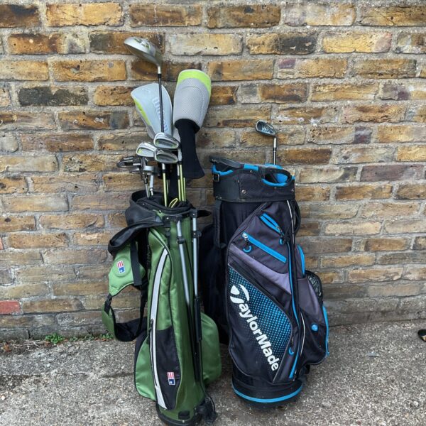 Wilson golf club set with TaylorMade trolley bag on display.
