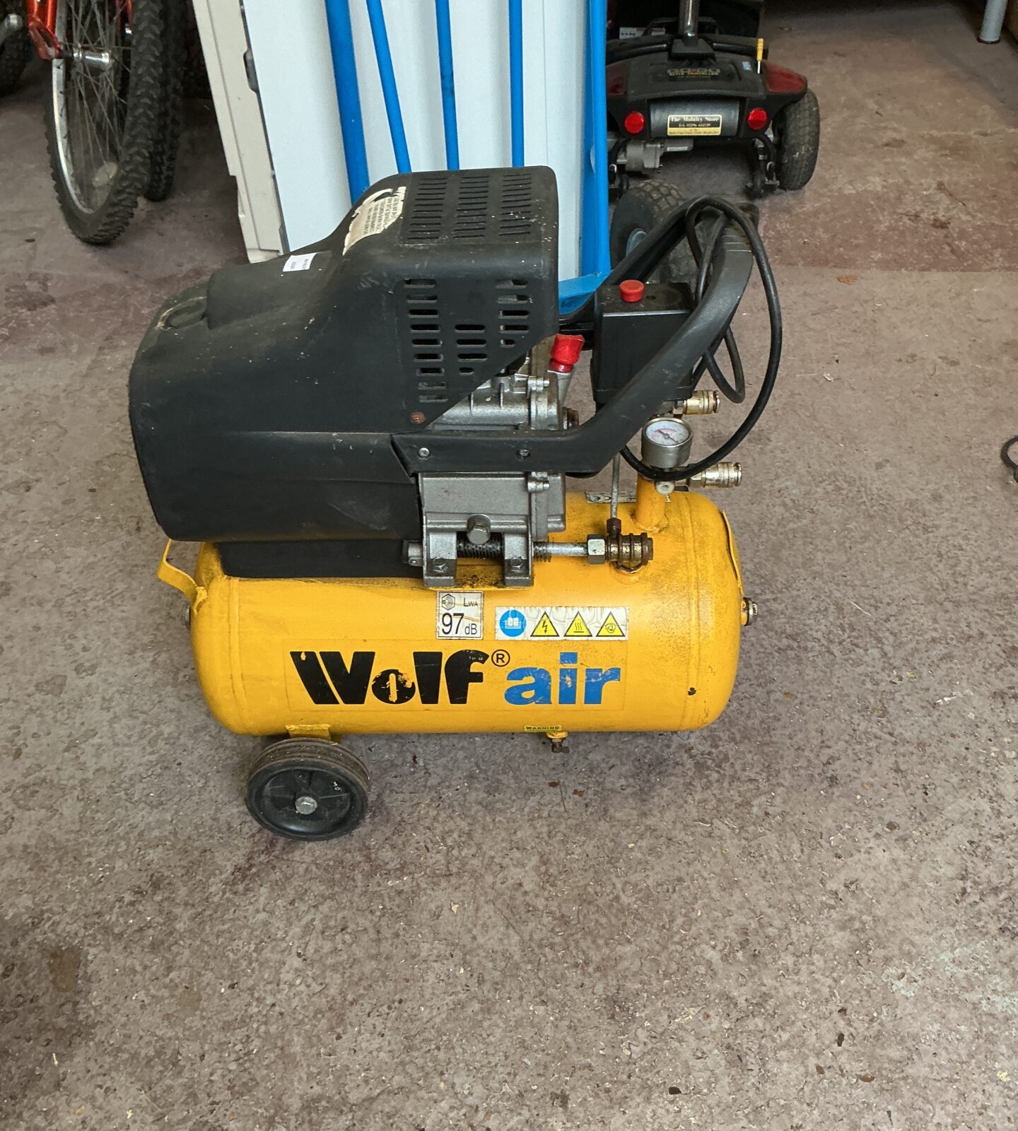 Portable Wolf air compressor with hose and gauge.