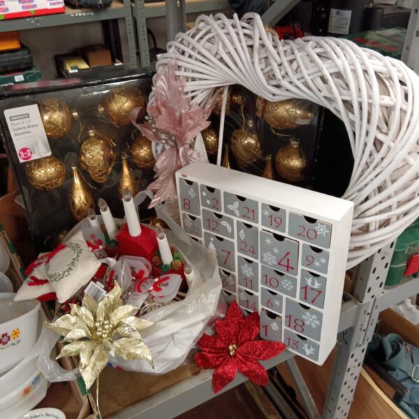 Vintage wooden advent calendar with Christmas decorations in background.