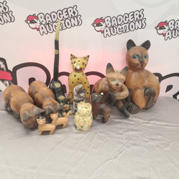 A collection of vintage wooden cat ornaments displayed together.