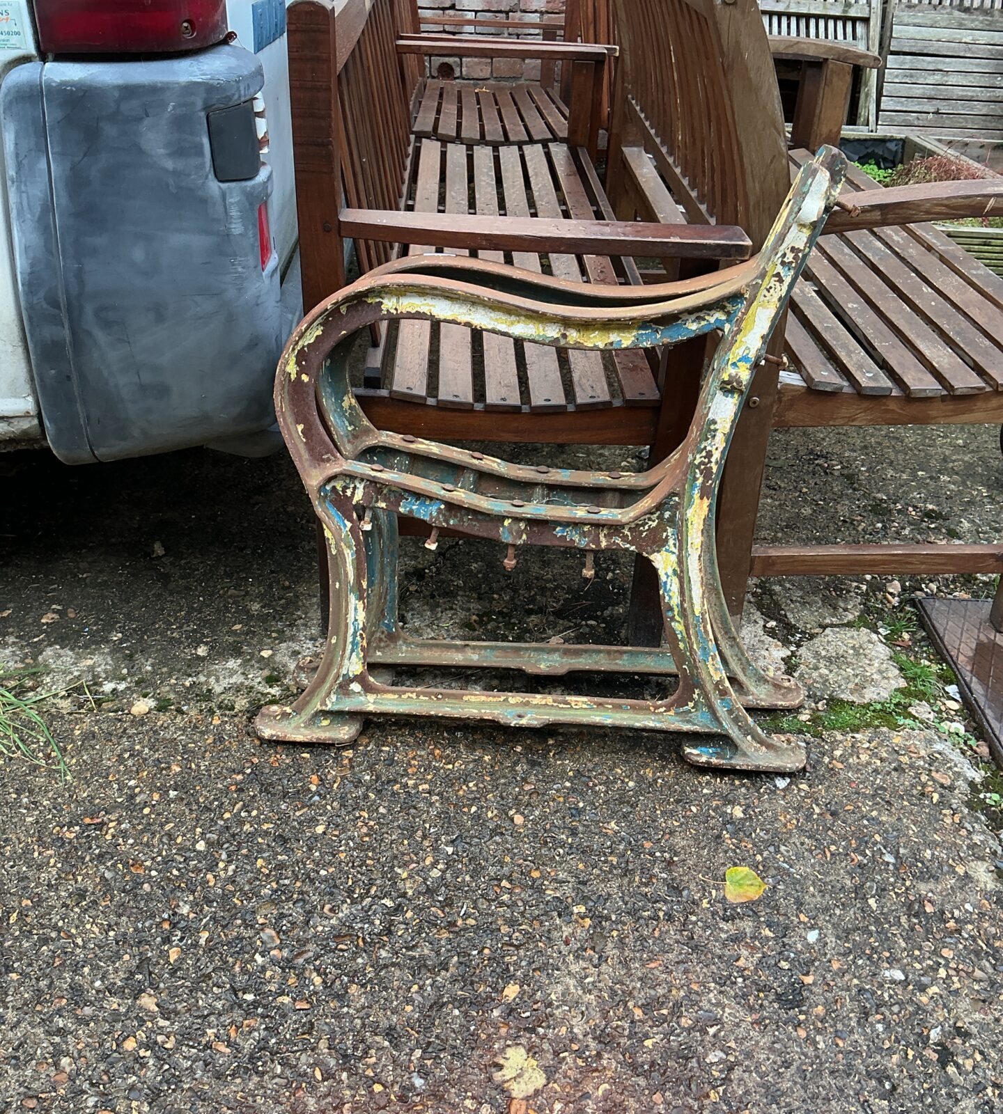Antique wrought iron bench ends with Victorian detailing for garden restoration.