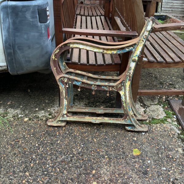 Antique wrought iron bench ends with Victorian detailing for garden restoration.
