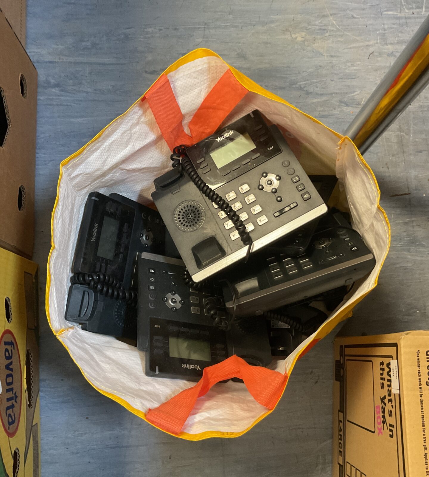 A bag of multiple Yealink office phones for business communication.