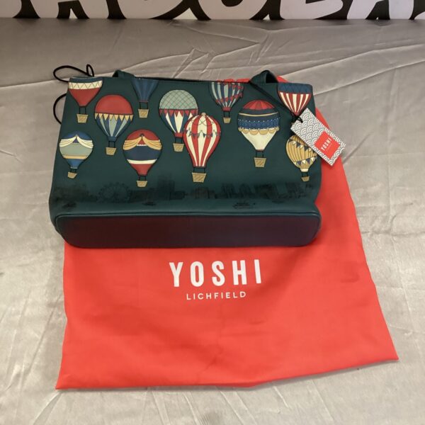 Front view of a new Yoshi handbag with repeating character pattern.